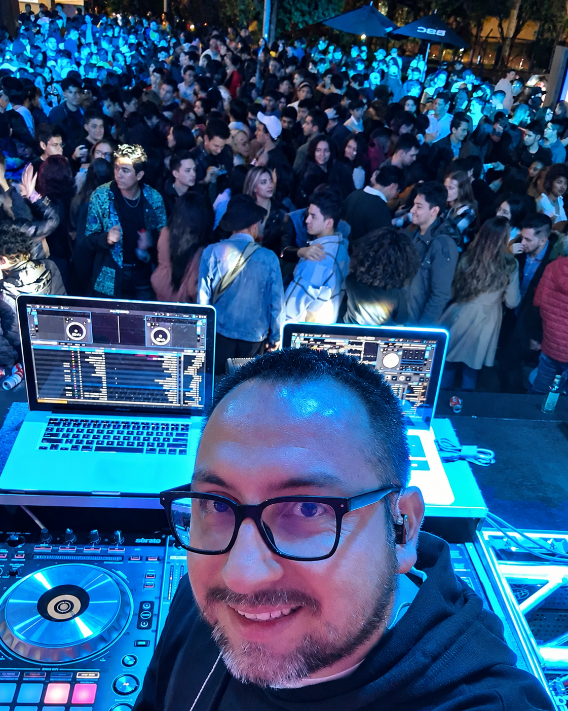 Ferbeatz DJ sonriendo en la cabina frente a una gran multitud al aire libre